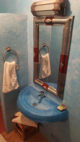 a bathroom with a blue sink and a mirror at Dar Bilal in Aït Ben Haddou