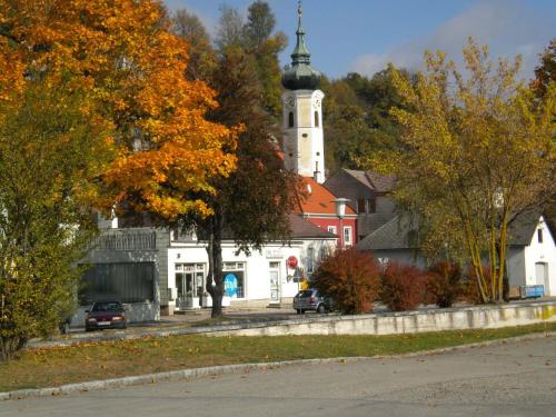 a church with a clock tower in a town at Gästezimmer Weiss in Maria Taferl