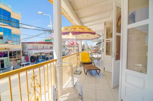 a balcony with an umbrella and chairs on it at Pleasant Stay Paramaribo in Paramaribo