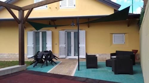 a patio with two black chairs and a house at Ostello Villafranca in Pignola