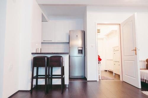 a kitchen with a refrigerator and two bar stools at Apartment Fila in Kochani
