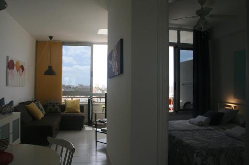 プラヤ・デ・ラス・アメリカスにあるApartamento Vacacional Playaのリビングルーム(ベッド1台、ソファ付)