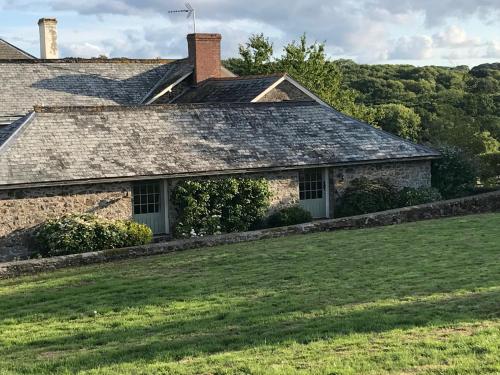 an old stone house with a green yard at The Cider Barn Boutique Holiday Cottage in Zeal Monachorum