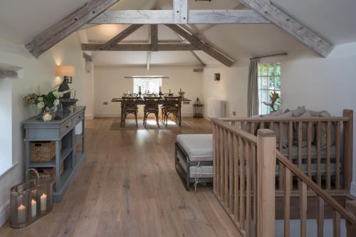 a living room with a dining room table and wooden floors at The Cider Barn Boutique Holiday Cottage in Zeal Monachorum