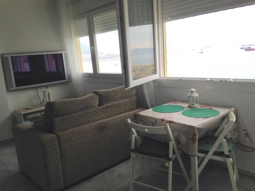 a living room with a couch and a table at Apartamentos vista a tres continentes in La Línea de la Concepción