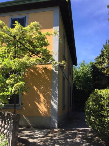 a yellow and white building with a door at Villa Monte Bianco in Mandello del Lario