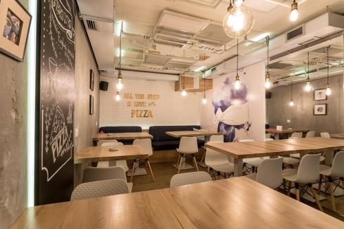 a restaurant with tables and chairs in a room at Smile apARTment in Novi Sad