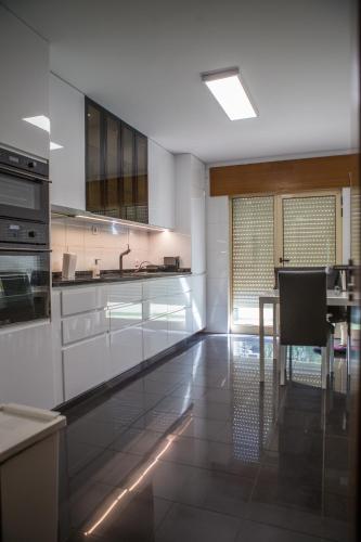 a kitchen with white cabinets and a table in it at PortoHouse in Porto
