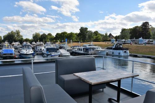 a balcony with a table and boats in a marina at Cosy floating boatlodge Athene in Maastricht