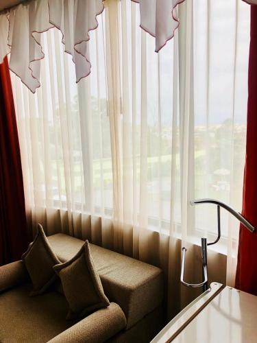 a couch sitting in front of a large window at D'ORLAND HOTEL in Santo Domingo de los Colorados