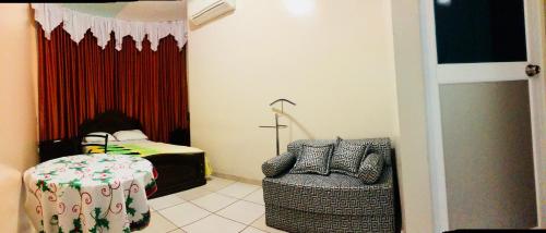 a bedroom with a bed and a table and a chair at D'ORLAND HOTEL in Santo Domingo de los Colorados