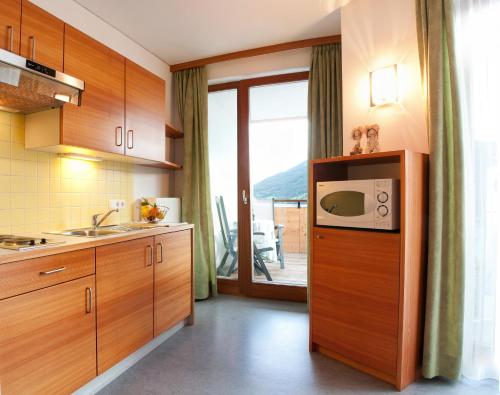 a kitchen with wooden cabinets and a microwave at Haus Lechthaler in Resia