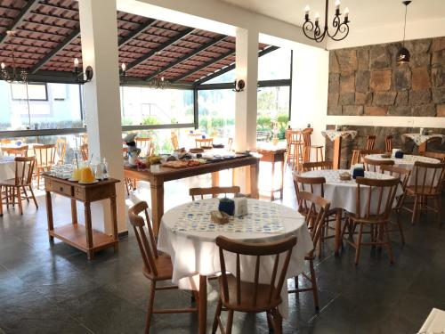 een restaurant met tafels en stoelen in een kamer bij Pousada Il Villaggio in Santo Antônio do Pinhal
