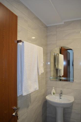 Baño blanco con lavabo y espejo en Ermar, en Tulcea