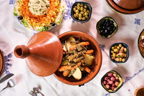 a table with a bowl of food and other dishes at Riad Ouarzazate in Ouarzazate
