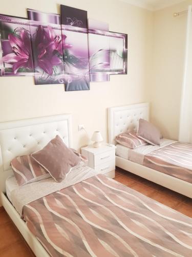 2 camas en un dormitorio con flores rosas en la pared en Apt a Calafell plage, en Calafell