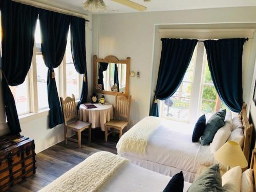 Hotel San Ramon في بيسبي: غرفة نوم بسريرين وطاولة ومرآة