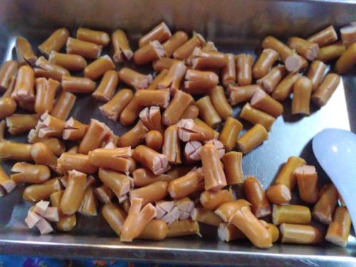 een stapel mini-hotdogs op een bakplaat bij Pechpailin Resort in Kanchanaburi