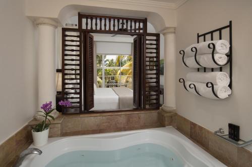 a bath tub in a bathroom with a mirror at Meliá Caribe Beach Resort-All Inclusive in Punta Cana