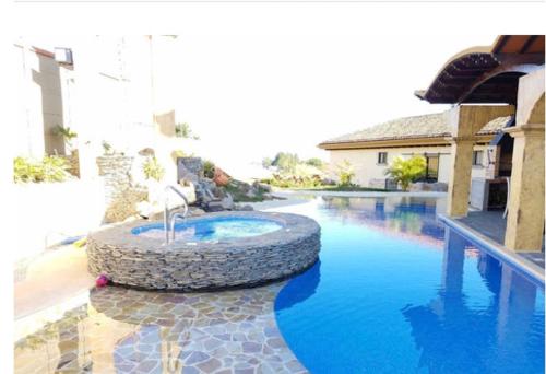 a fountain in the middle of a swimming pool at Villa El Retiro Luxury Property in Alajuela City