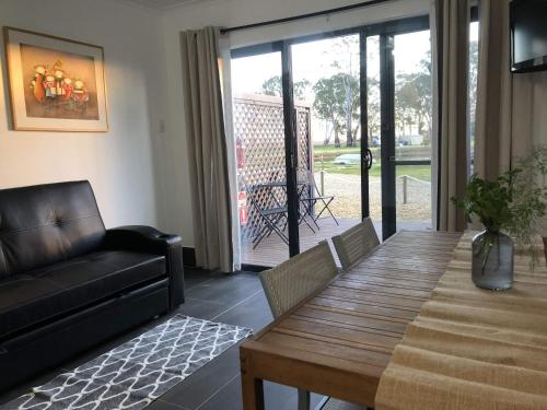 a living room with a wooden table and a couch at Coonawarra Ensuite Unit B in Coonawarra