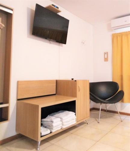 a room with a desk with a chair and a television at Premium Mendoza Apart Hotel in Mendoza