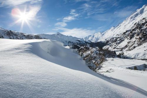 a snow covered mountain with the sun in the background at Alpenaussicht in Obergurgl