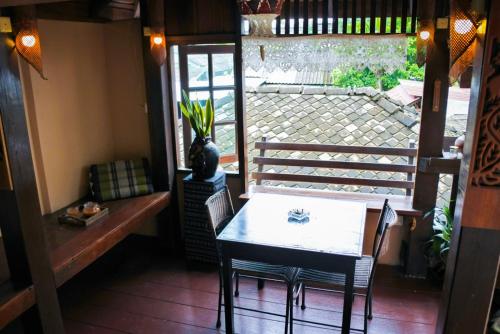 comedor con mesa, sillas y ventana en The North Hotel, en Chiang Rai