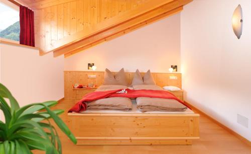 ein Schlafzimmer mit einem Holzbett in einem Zimmer in der Unterkunft Sieberlechnerhof in Lüsen