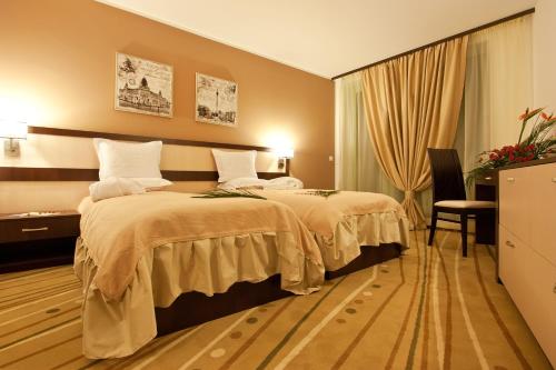 a hotel room with a bed, chair, and nightstand at Earth & People Hotel & SPA in Sofia