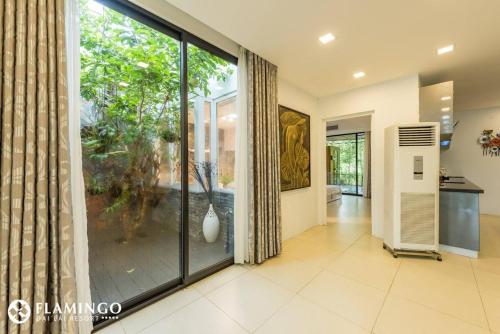 a large glass door in a room with a large window at FLAMINGOS Villa Happy BT in Ngọc Quang