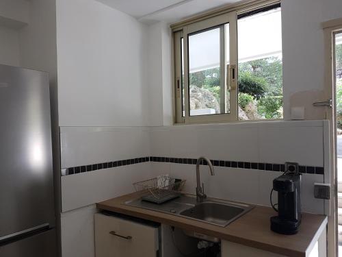 uma cozinha com um lavatório e uma janela em Venus - Climatisé - Marina Baie des Anges em Villeneuve-Loubet