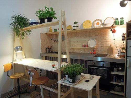 ミラノにあるDesign Double View Flatの棚付きキッチン、植物テーブル