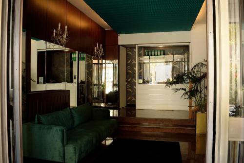 a living room with a green couch and a door at Residenze Venezia Apartments in Mestre
