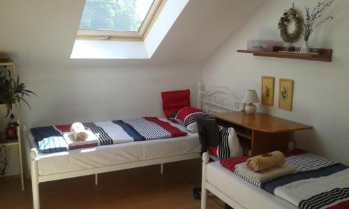 um quarto com duas camas e uma mesa e uma janela em Apartmán Danka em Banská Bystrica