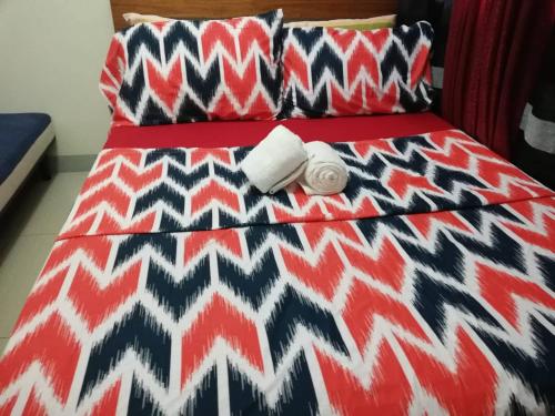 a bed with a black and white comforter and pillows at Nica's Place Property Management Services at Horizons 101 Condominium in Cebu City