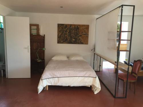 a bedroom with a bed and a painting on the wall at 20B - KERMARQUER - STUDIO 1 48m² in La Trinité-sur-Mer