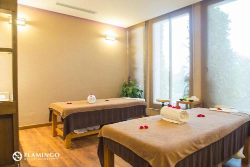 a room with two beds with red flowers on them at FLAMINGOS Villa Happy 3 phòng ngủ- view Hồ- bể bơi riêng in Ngọc Quang