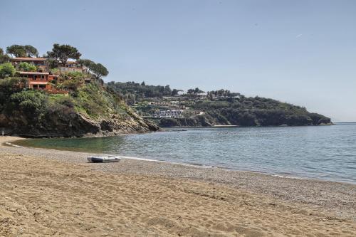 a beach with a boat laying on the sand at Rosa dei Venti Est in Capoliveri