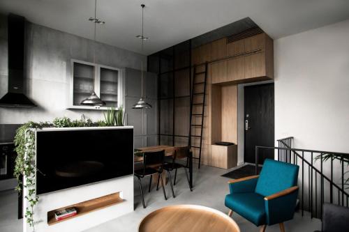 een woonkamer met een grote televisie en een eetkamer bij G - Owl Jazz - Modern and spacious loft type apartment 8 with free private parking in Kaunas
