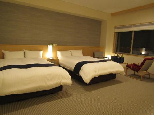 気仙沼市にある網元の宿 磯村のベッド2台と窓が備わるホテルルームです。