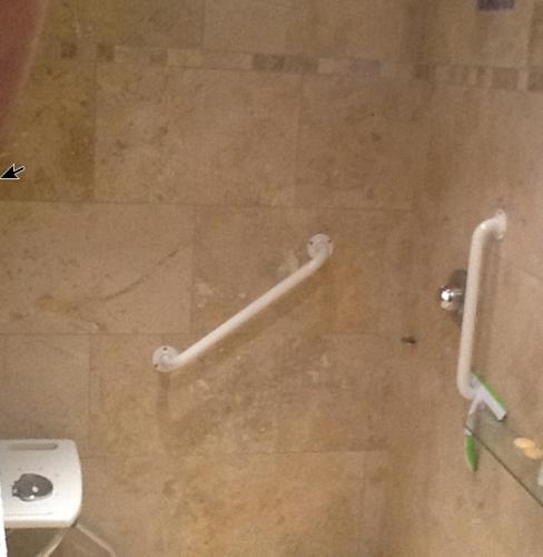 a bathroom stall with a toilet and a handicap bar at Holly Lodge in Alnwick