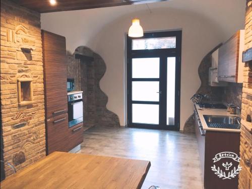 uma cozinha com uma porta que leva a uma cozinha com pisos de madeira em La Taverna del Marchigiano em SantʼEusanio del Sangro