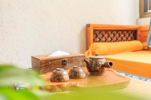 a table with two tea pots and a box at Dali Buxianshan Boutique Guesthouse-in Dali ancient city in Dali