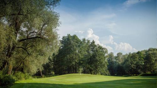 a view of a golf course with trees and a green at Villa Green in Sliač