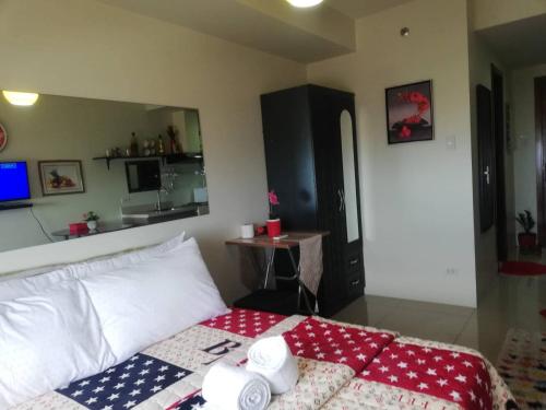 a bedroom with a bed and a table in it at Nica's Place Property Management Services at Horizons 101 Condominium in Cebu City