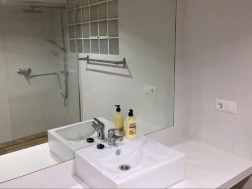 biała łazienka z umywalką i lustrem w obiekcie Beach apartment garden and wifi w mieście Tarifa