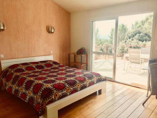 um quarto com uma cama e uma porta de vidro deslizante em Villa Belles vues em Saint-Gély-du-Fesc