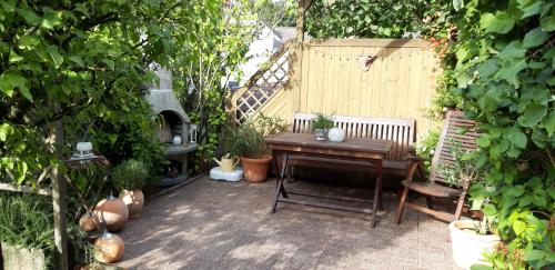a garden with a wooden table and a bench at FeWo Hage in Langelsheim