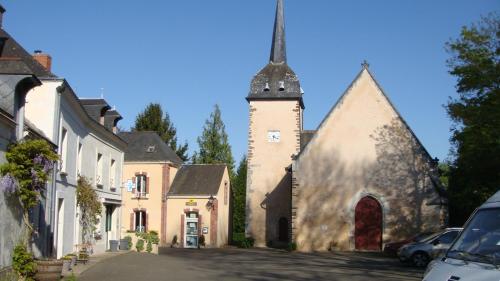 una vecchia chiesa con una torre e una strada di gite montreuil le henri 2 pers a Montreuil-le-Henri